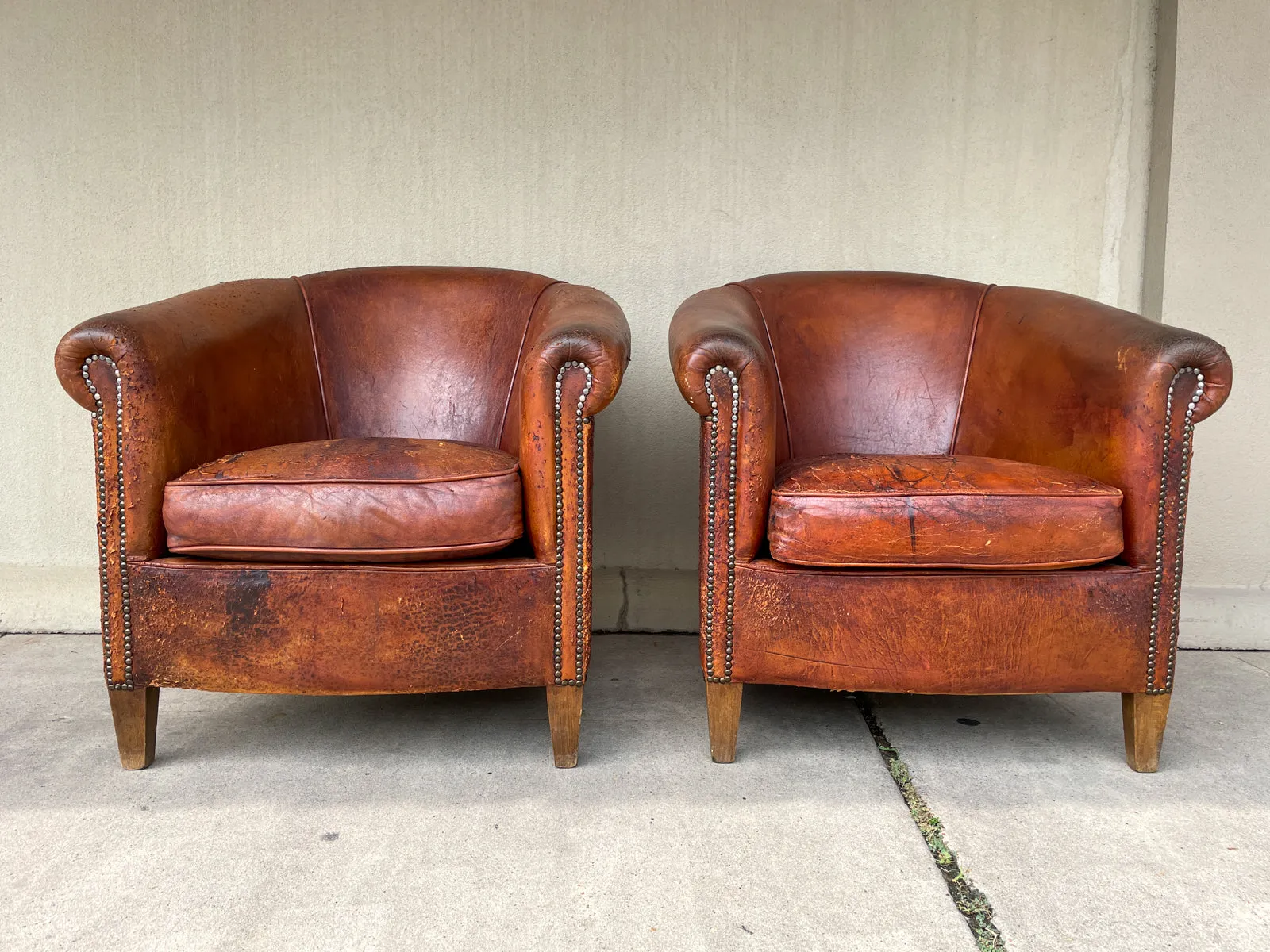 Pair Distressed Vintage European Leather Tub Chairs with Brass Nailhead Detail
