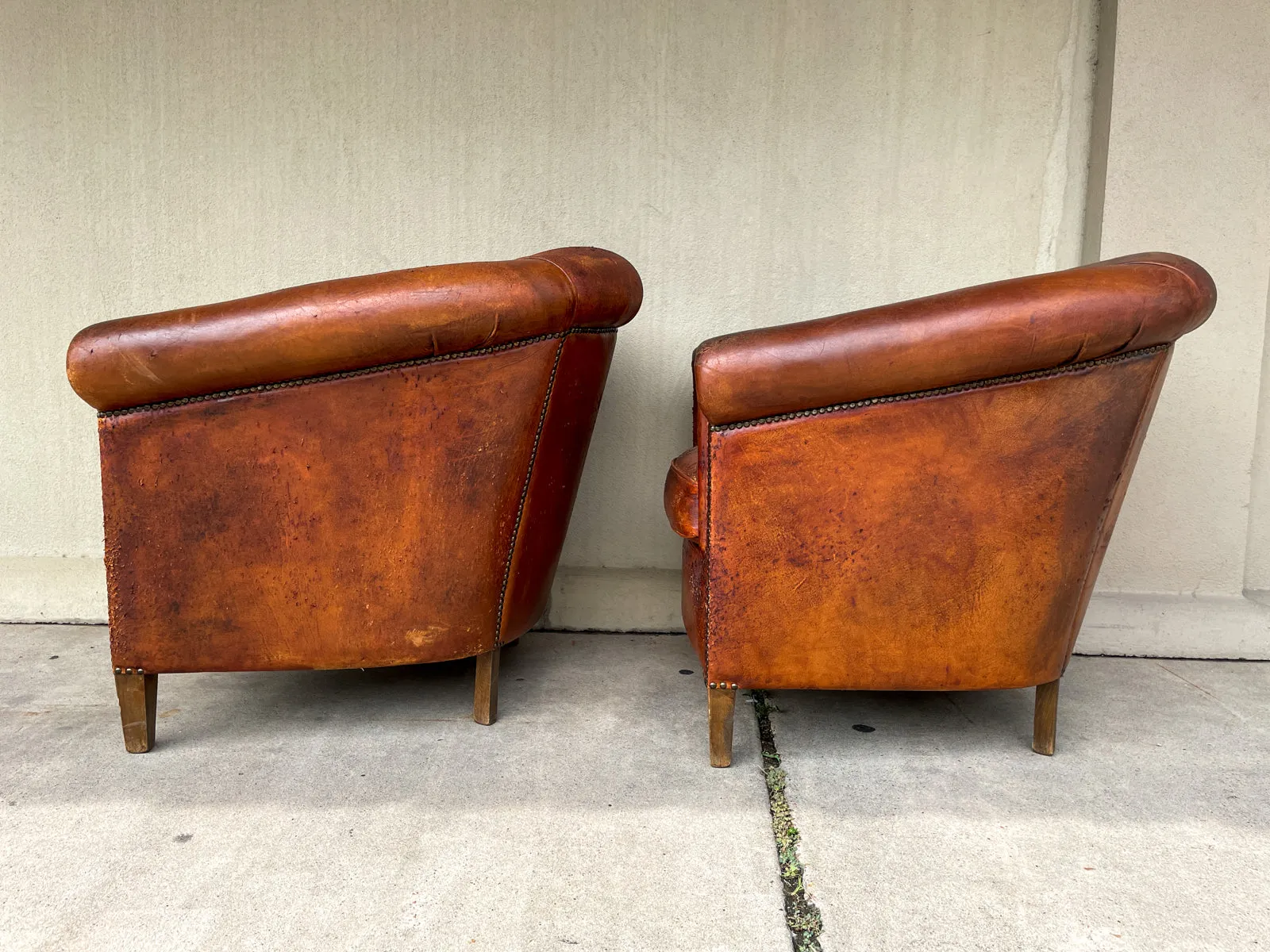 Pair Distressed Vintage European Leather Tub Chairs with Brass Nailhead Detail