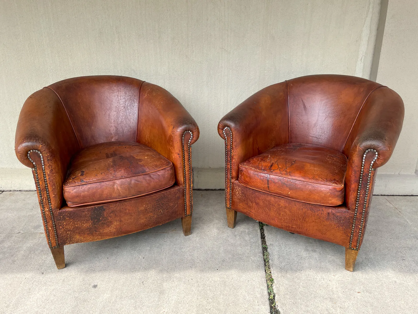 Pair Distressed Vintage European Leather Tub Chairs with Brass Nailhead Detail