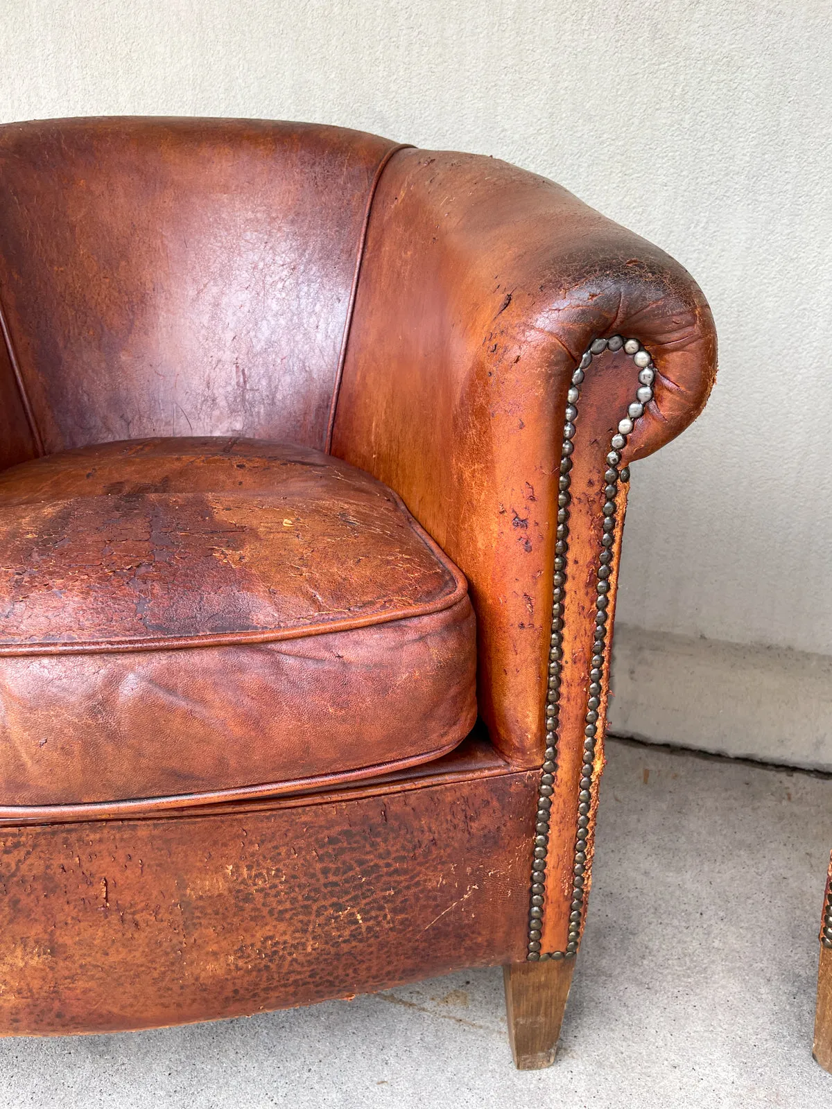 Pair Distressed Vintage European Leather Tub Chairs with Brass Nailhead Detail