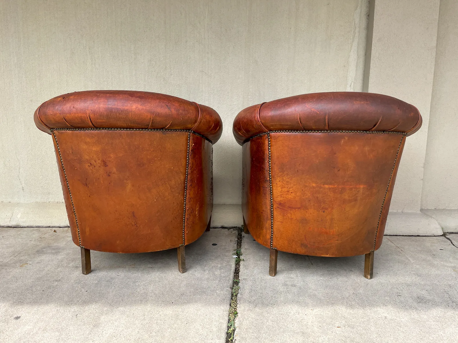 Pair Distressed Vintage European Leather Tub Chairs with Brass Nailhead Detail