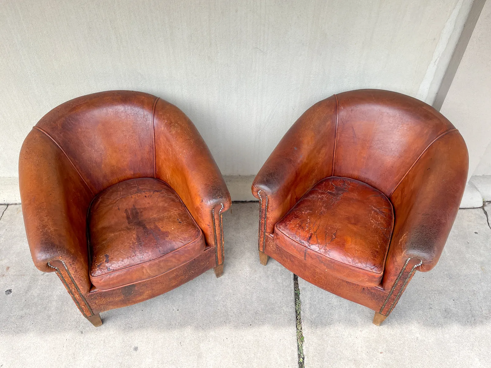 Pair Distressed Vintage European Leather Tub Chairs with Brass Nailhead Detail