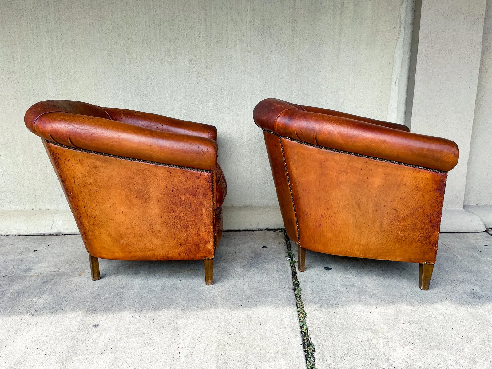 Pair Distressed Vintage European Leather Tub Chairs with Brass Nailhead Detail