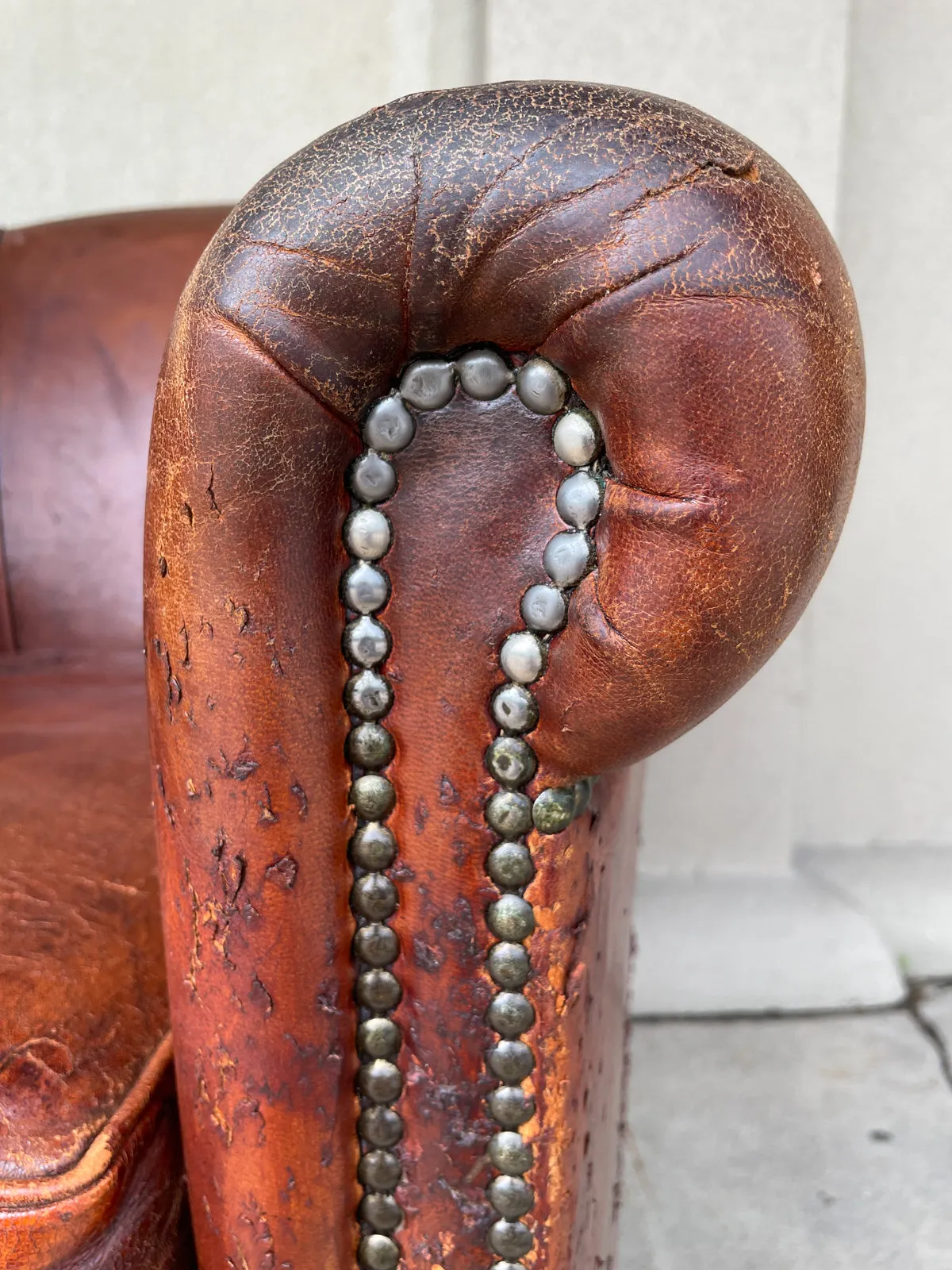 Pair Distressed Vintage European Leather Tub Chairs with Brass Nailhead Detail