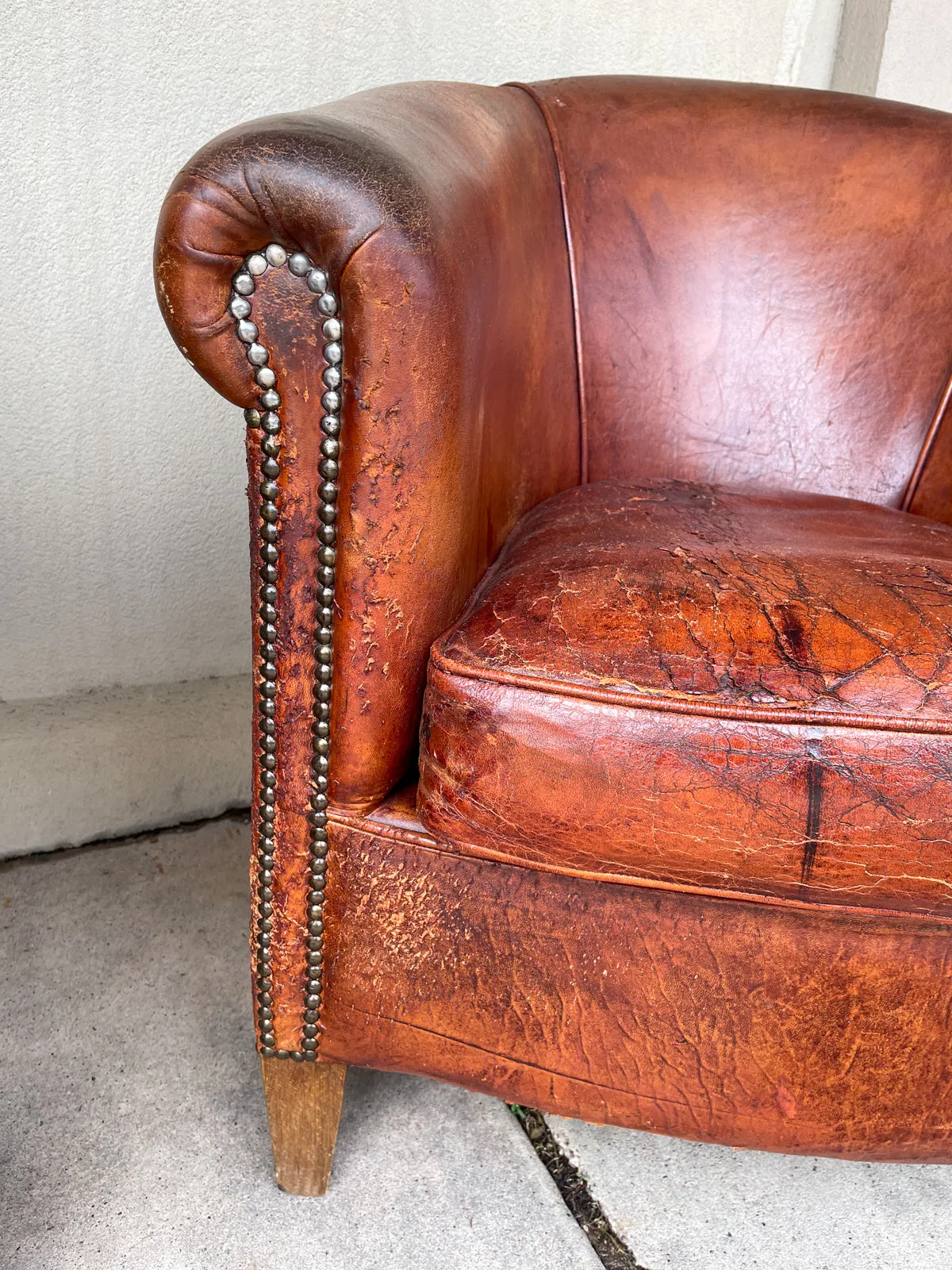 Pair Distressed Vintage European Leather Tub Chairs with Brass Nailhead Detail