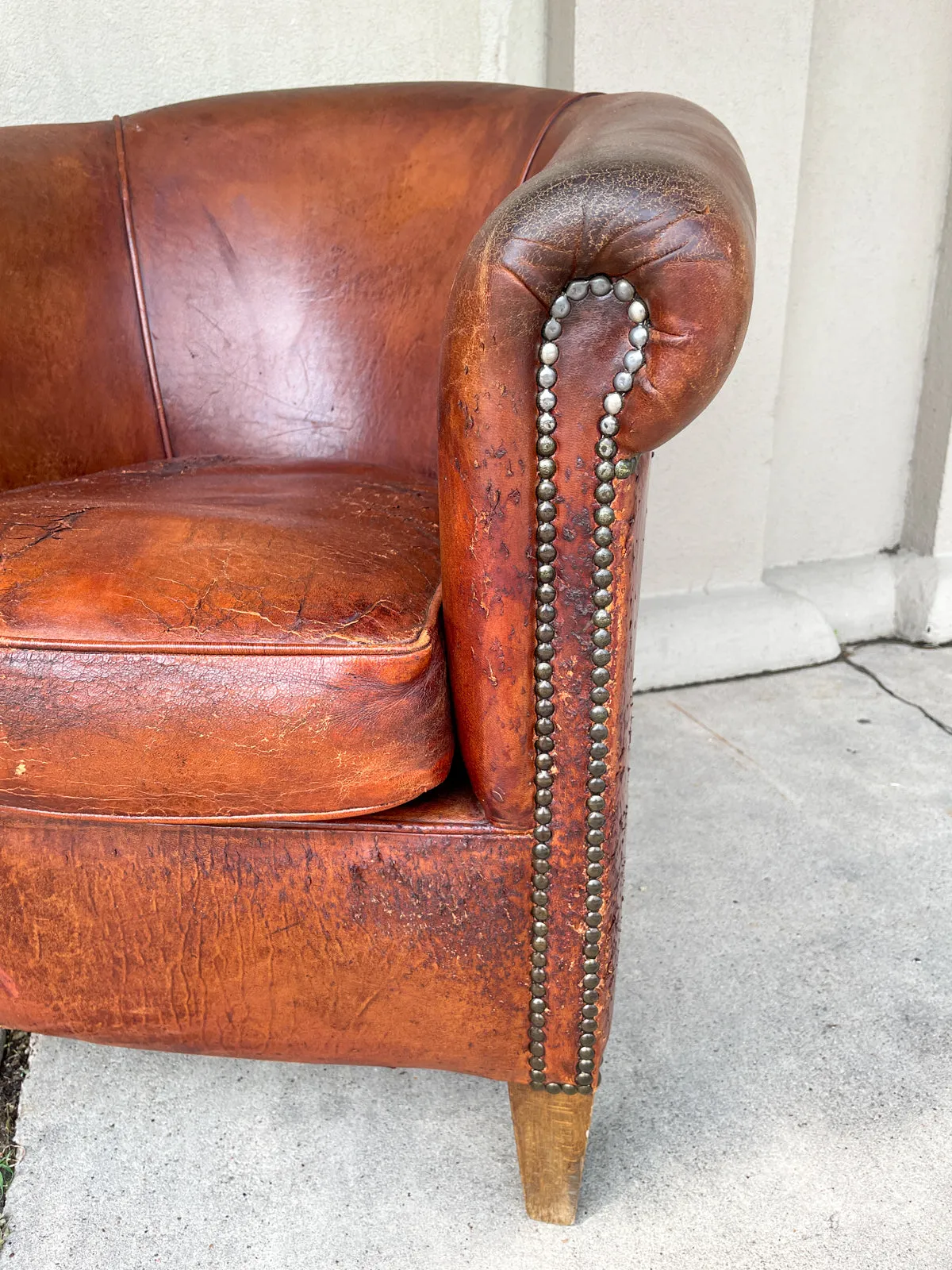 Pair Distressed Vintage European Leather Tub Chairs with Brass Nailhead Detail